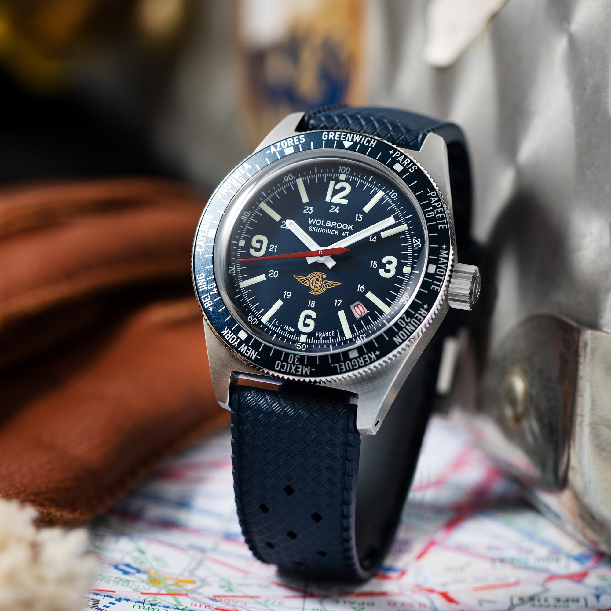 Wolbrook Skindiver WT Automatic Aéro-Club de France Special Edition watch with blue Tropic rubber strap in front of vintage travel trunk